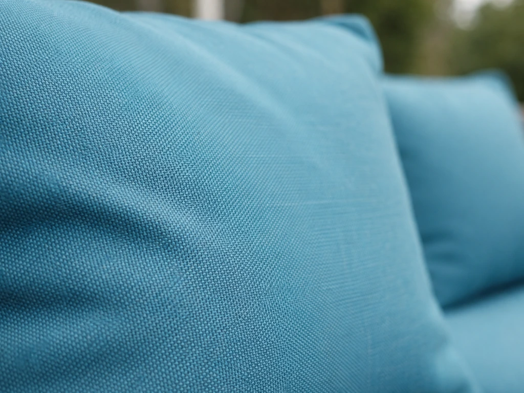 Close-up of solution-dyed acrylic outdoor cushion fabric showing rich color and textured weave.