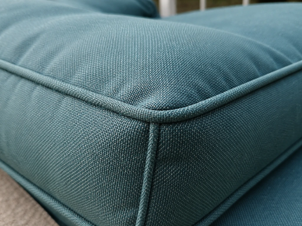 Close-up of solution-dyed acrylic outdoor cushion fabric showing even color and sturdy stitching.