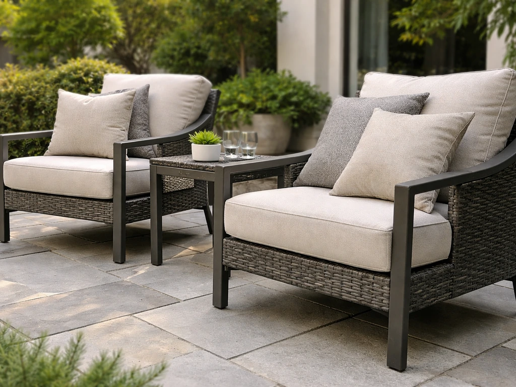 Gunmetal and resin-woven patio furniture with cushioned seating on a quiet outdoor patio