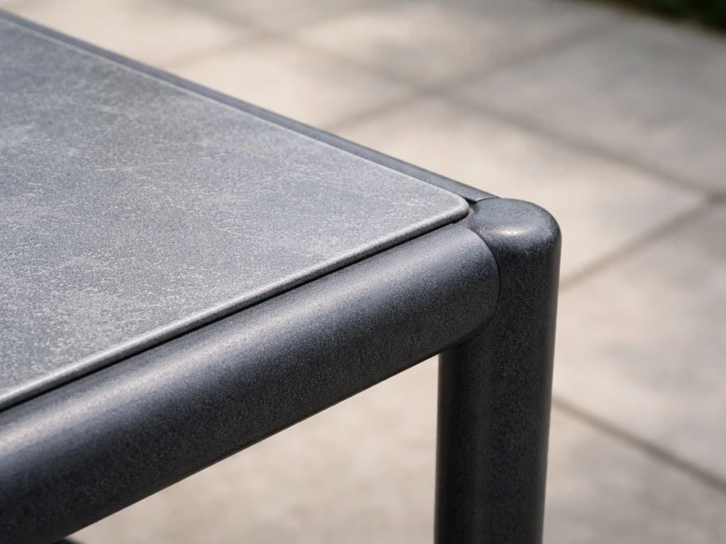 Close-up of a powder-coated steel patio furniture frame and tabletop surface in natural light
